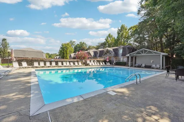 a view of swimming pool with outdoor seating and a pathway