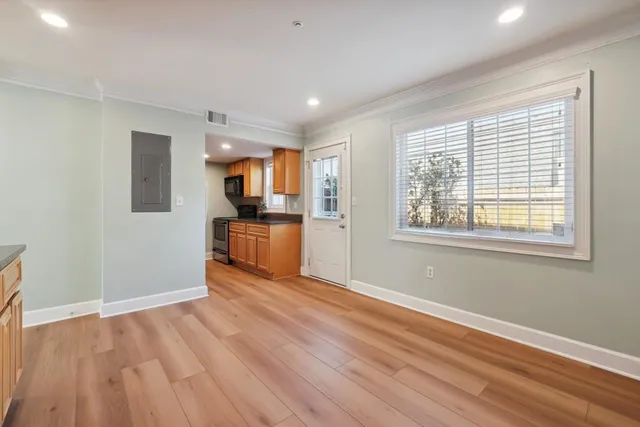 a view of a kitchen with wooden floor and electronic appliances