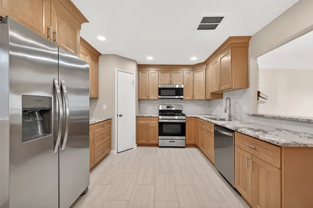 a kitchen with granite countertop a sink and cabinets
