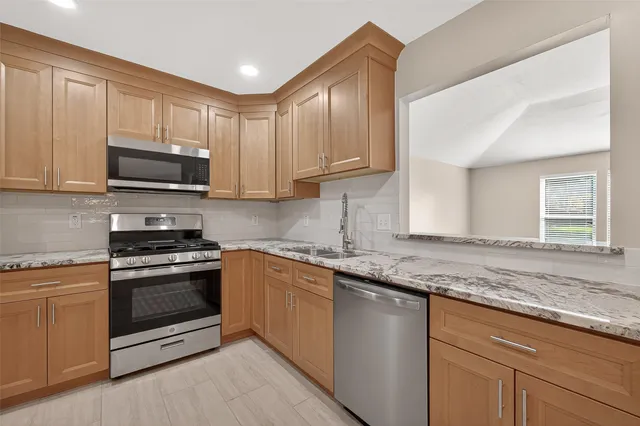 a kitchen with granite countertop a refrigerator and a sink