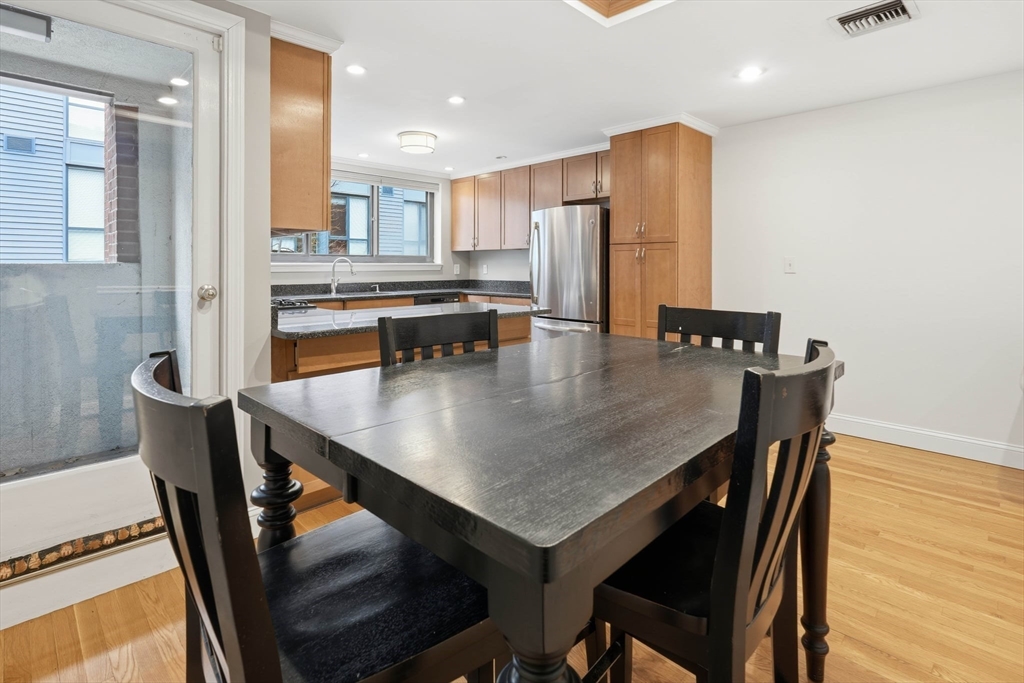 85 Brainerd Road, Unit TH7 Boston, MA 02134 - Photo 12 of 41 a dining room with stainless steel appliances a table and chairs