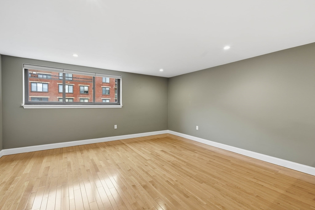 85 Brainerd Road, Unit TH7 Boston, MA 02134 - Photo 24 of 41 a view of an empty room with wooden floor and a window