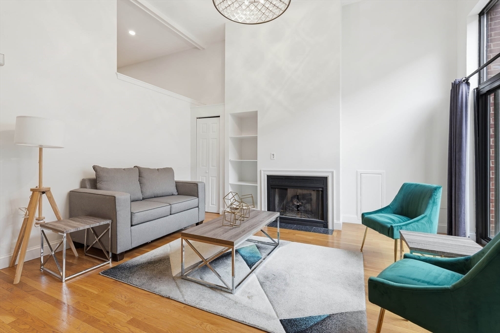 85 Brainerd Road, Unit TH7 Boston, MA 02134 - Photo 4 of 41 a living room with furniture a fireplace and a table