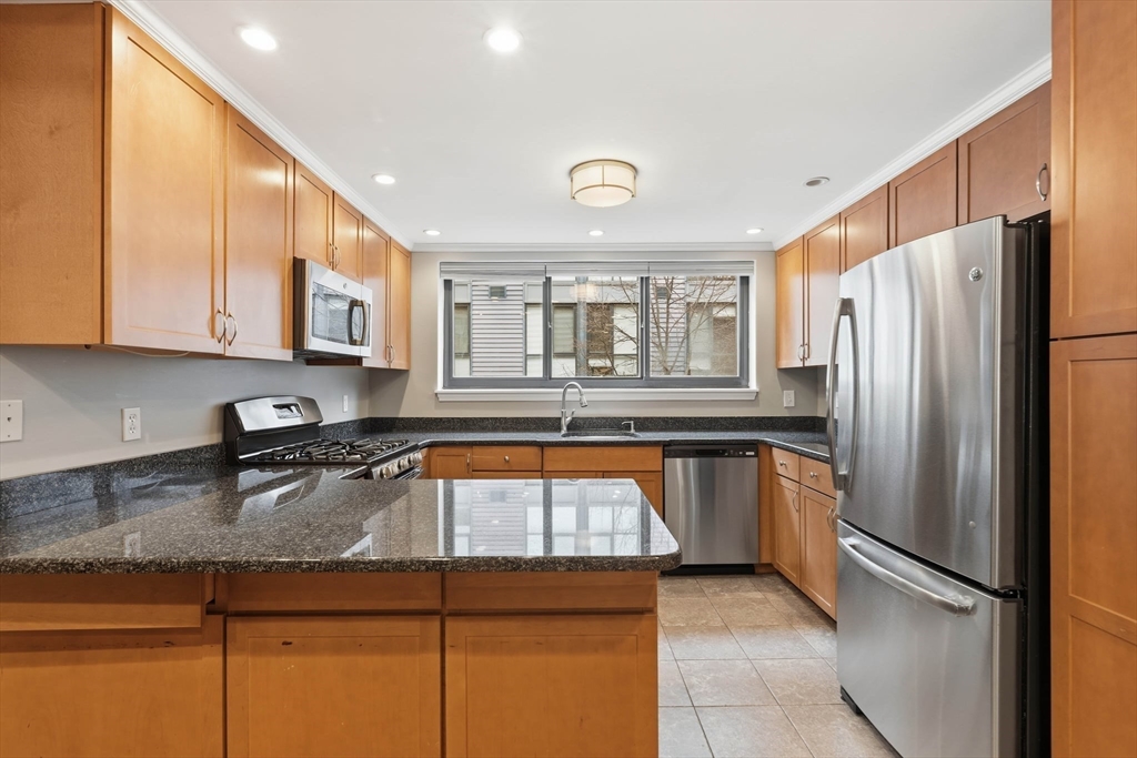 85 Brainerd Road, Unit TH7 Boston, MA 02134 - Photo 9 of 41 a kitchen with stainless steel appliances granite countertop a refrigerator and a sink