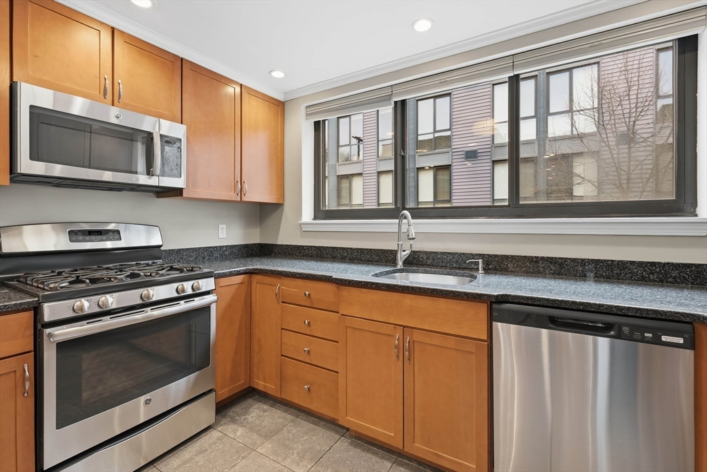 85 Brainerd Road, Unit TH7 Boston, MA 02134 - Photo 10 of 41 a kitchen with stainless steel appliances granite countertop a stove microwave and cabinets