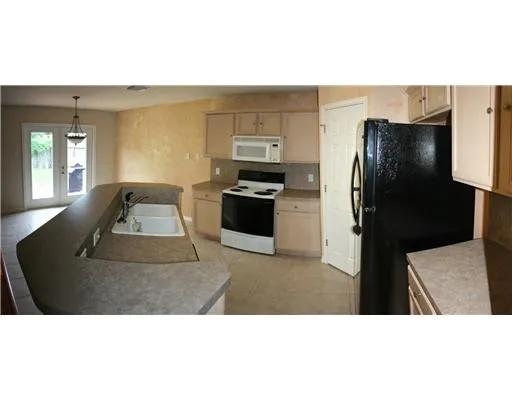 a kitchen with a refrigerator and a stove