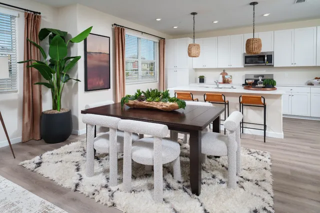 a kitchen with stainless steel appliances kitchen island granite countertop a table and chairs in it