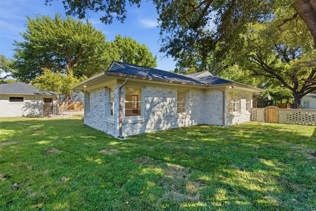 a view of a wooden house with a big yard