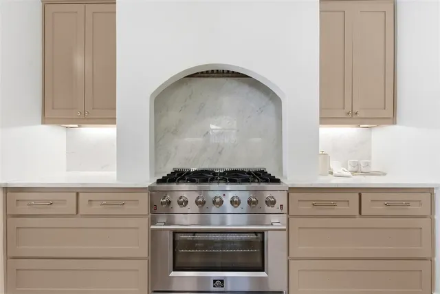a stove top oven sitting inside of a kitchen