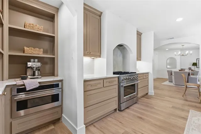 a kitchen with stainless steel appliances kitchen island wooden floors and white cabinets