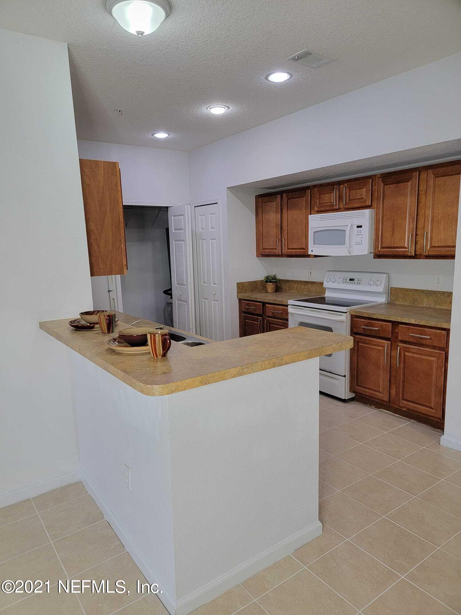 3641 Kirkpatrick Circle, Unit 4 Jacksonville, FL 32210 - Photo 7 of 17 a kitchen with stainless steel appliances granite countertop a sink a stove and a refrigerator