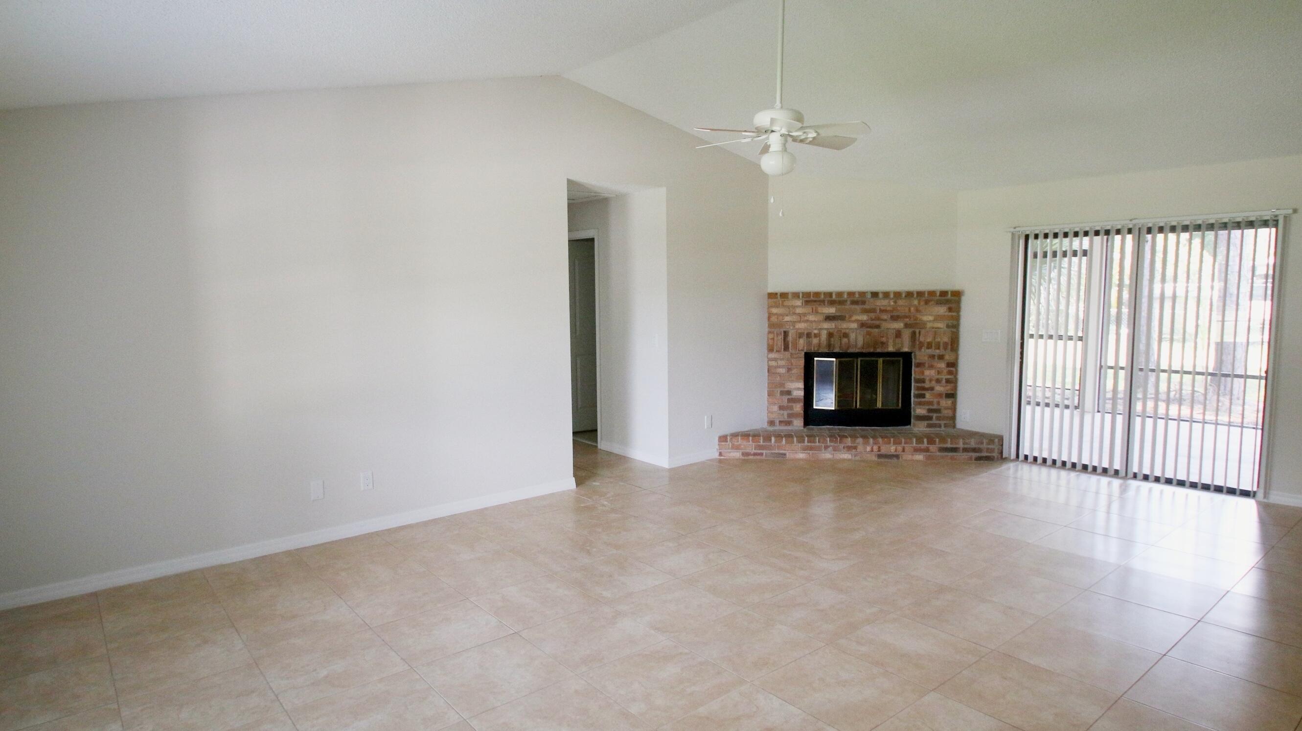 1137 Southwest Estaugh Avenue Port St. Lucie, FL 34953 - Photo 2 of 11 a view of an empty room with a fireplace and a window