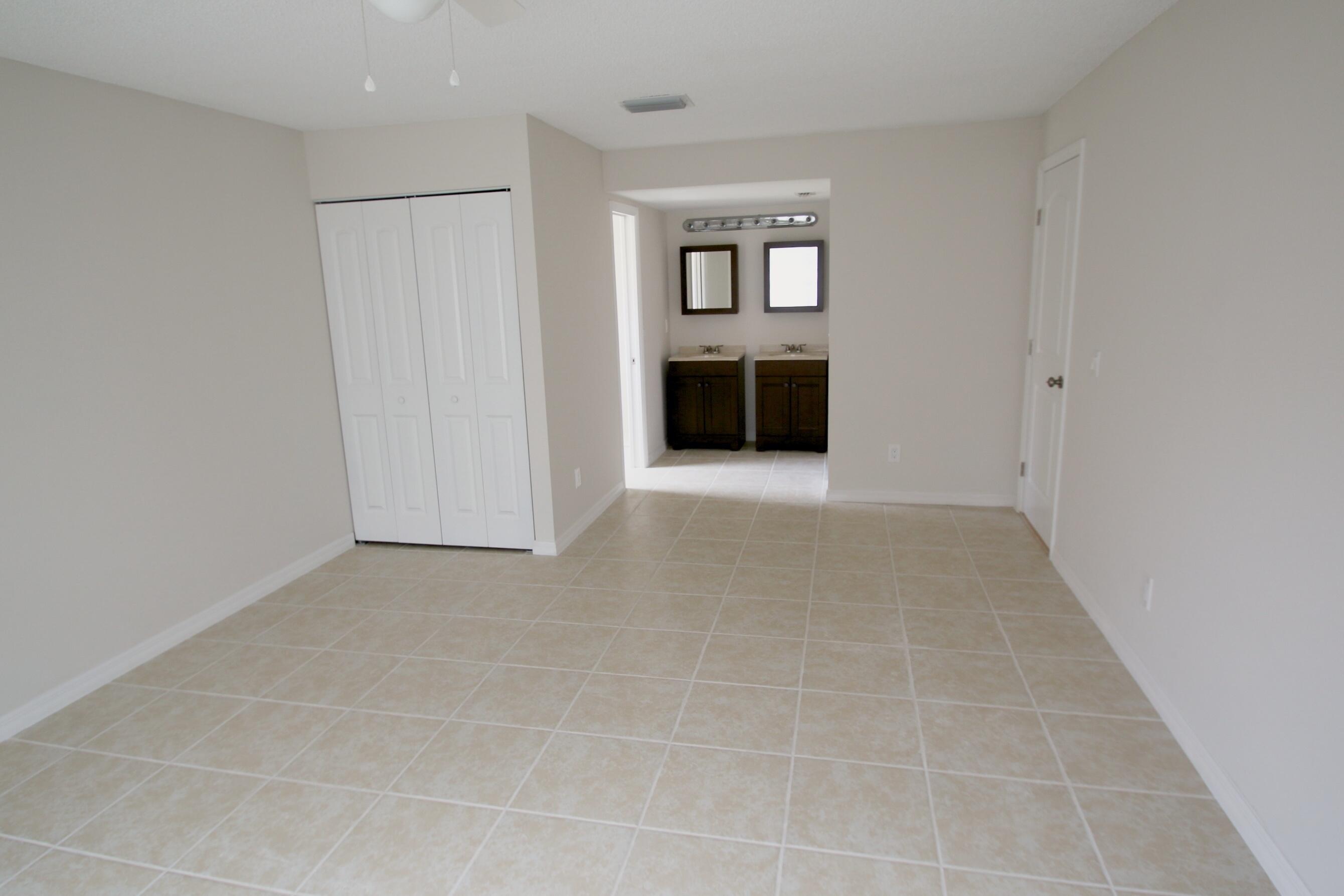 1137 Southwest Estaugh Avenue Port St. Lucie, FL 34953 - Photo 5 of 11 an empty room with a fireplace and a window