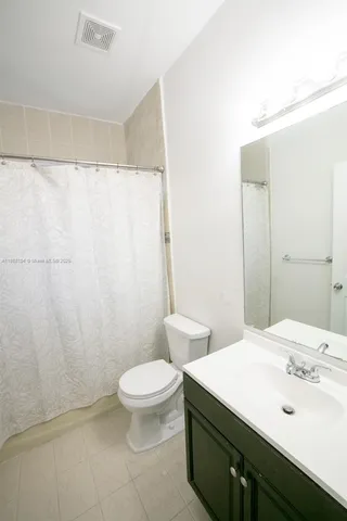 a bathroom with a sink a toilet and shower curtain