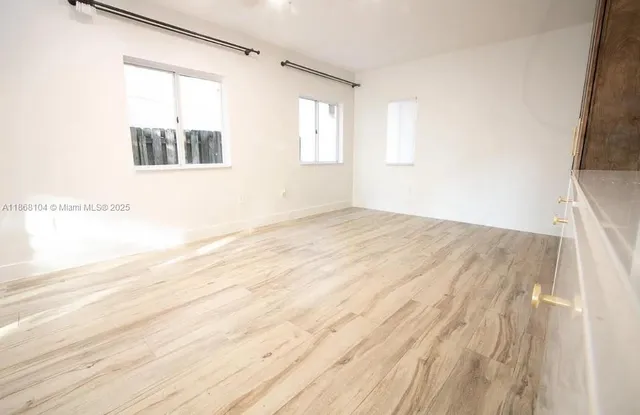 a view of a room with wooden floor and windows
