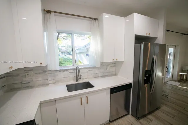 a kitchen with stainless steel appliances a sink stove and refrigerator