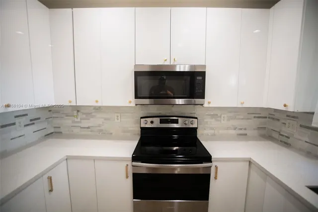 a kitchen with a stove and a white cabinets