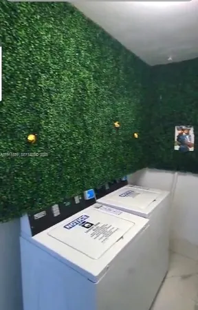 a view of a white house with a backyard