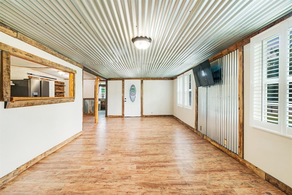 735 1st Southwest Detroit, TX 75436 - Photo 4 of 26 a view of a hallway with wooden floor and a kitchen