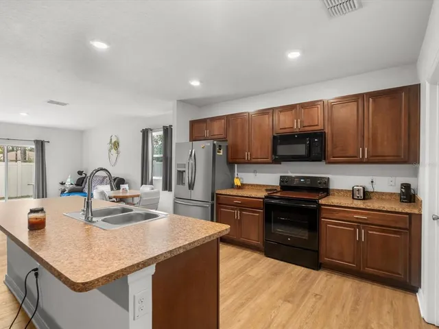 a large kitchen with granite countertop a large counter top stainless steel appliances and cabinets