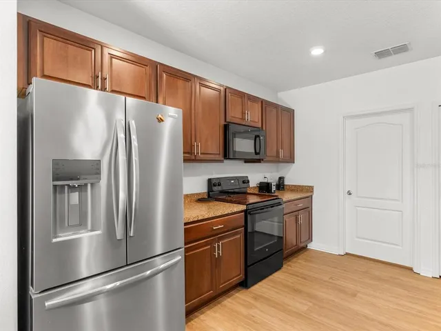 a kitchen with stainless steel appliances granite countertop a sink stove and refrigerator