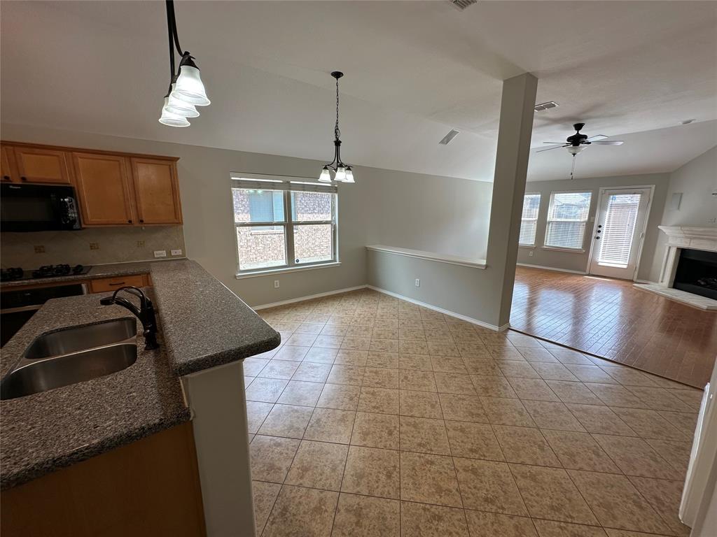 9321 Fenway Drive McKinney, TX 75072 - Photo 9 of 22 a kitchen with granite countertop a stove a sink and a counter top space