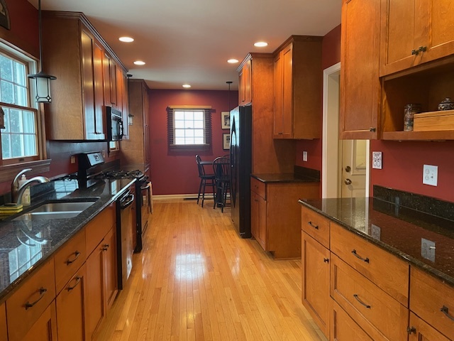 1505 West Acres Road Joliet, IL 60435 - Photo 11 of 42 a kitchen with stainless steel appliances granite countertop a sink and wooden cabinets