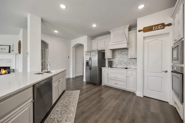a kitchen with stainless steel appliances sink refrigerator and cabinets