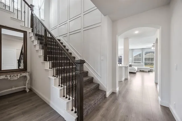 a view of a hallway with wooden floor and staircase