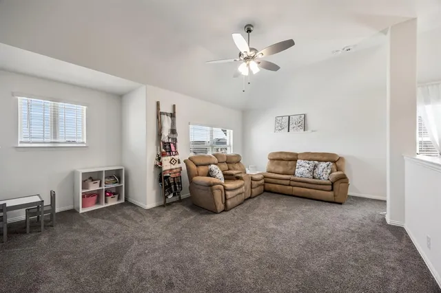 a living room with furniture and a ceiling fan