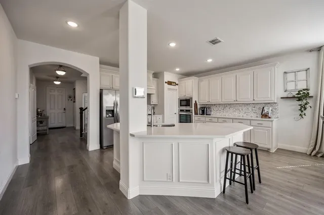 a kitchen with white cabinets and stainless steel appliances