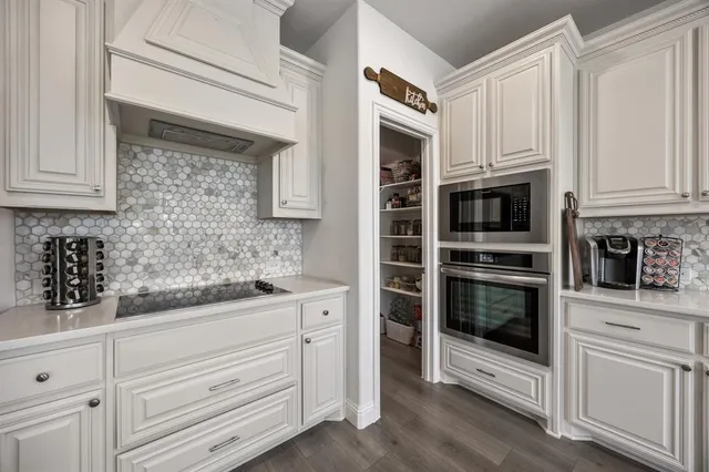 a kitchen with white cabinets and stainless steel appliances