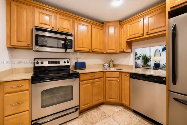 a kitchen with stainless steel appliances granite countertop white cabinets granite counter tops and a window
