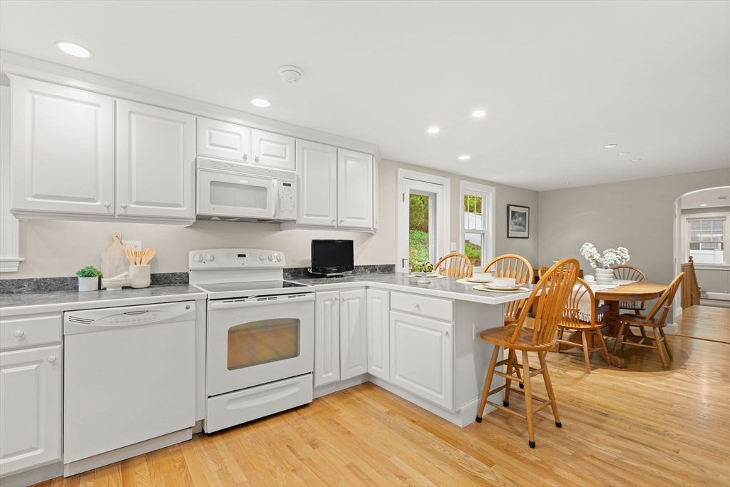 5 Brewster Road Arlington, MA 02478 - Photo 9 of 39 a kitchen with a white cabinets and chairs in it