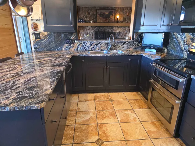 a kitchen with stainless steel appliances granite countertop a stove a sink and a microwave