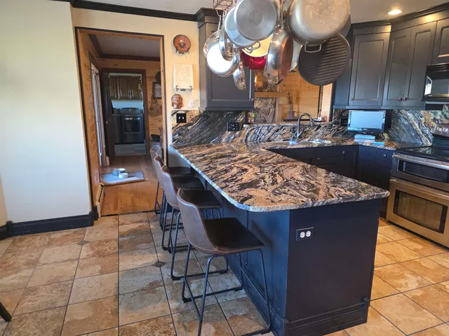 a kitchen with stainless steel appliances granite countertop a stove a sink and a refrigerator