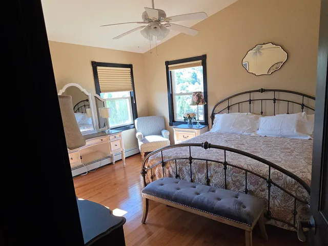 a bedroom with a bed and a lamp on dresser