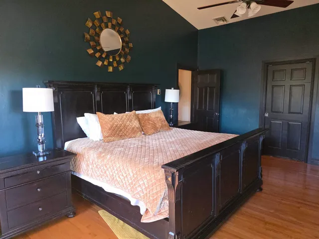a bedroom with a bed and flat tv screen on the dresser