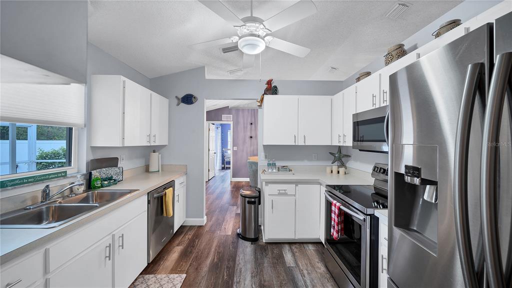 5219 Inverness Drive Sarasota, FL 34243 - Photo 2 of 32 a kitchen with a sink a refrigerator a washer dryer and cabinets