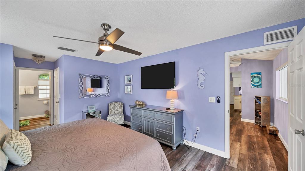 5219 Inverness Drive Sarasota, FL 34243 - Photo 8 of 32 a bedroom with a bed and a flat tv screen on dresser