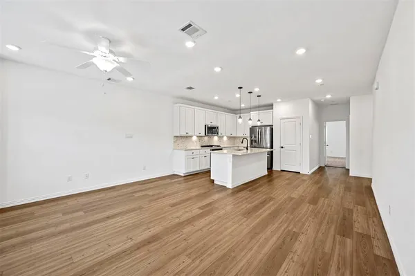 a kitchen with stainless steel appliances a sink a stove and a wooden floors