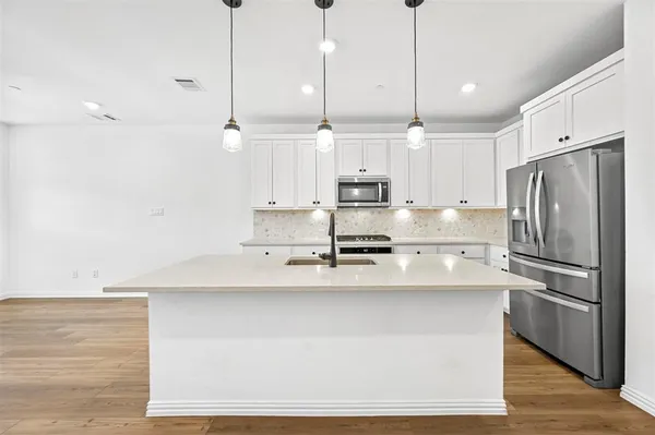a kitchen with stainless steel appliances a refrigerator a sink and a stove