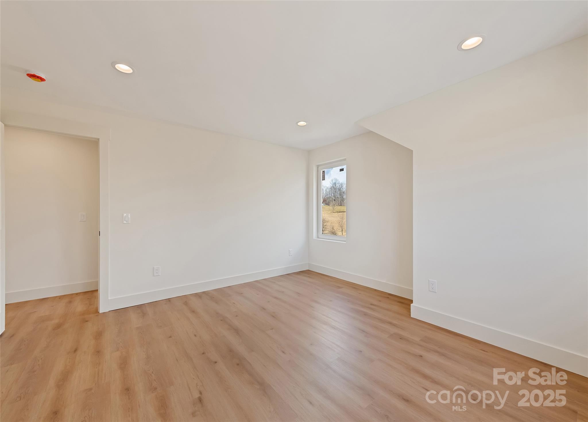 40 Firefly Ridge Trail Alexander, NC 28701 - Photo 24 of 33 an empty room with wooden floor and windows