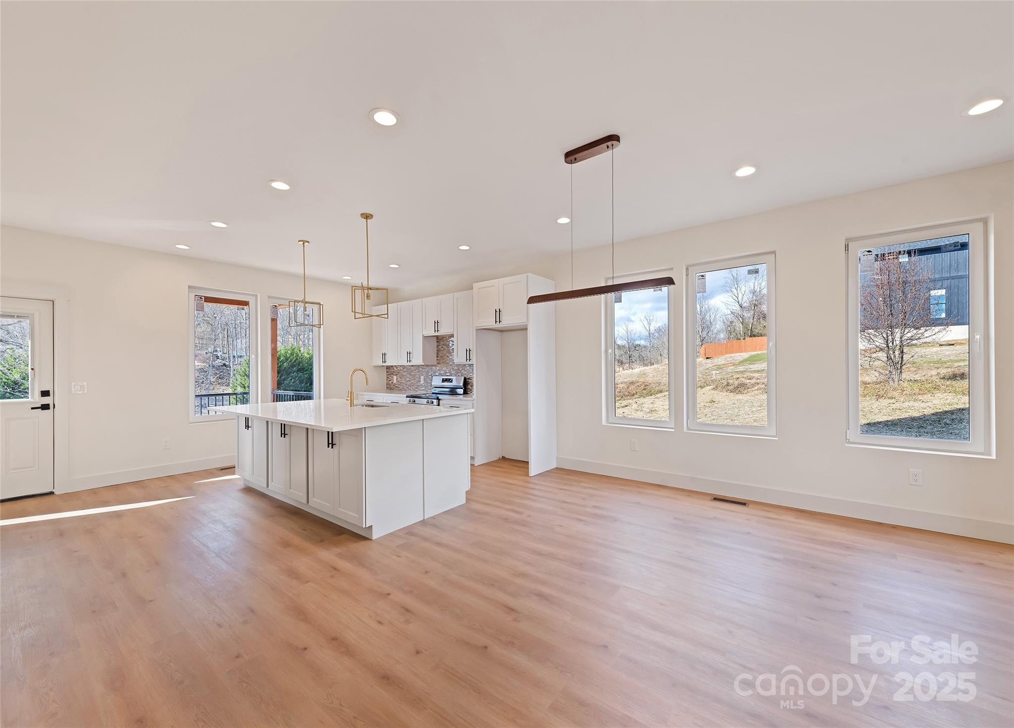 40 Firefly Ridge Trail Alexander, NC 28701 - Photo 10 of 33 a large kitchen with stainless steel appliances granite countertop a large window a oven and white cabinets