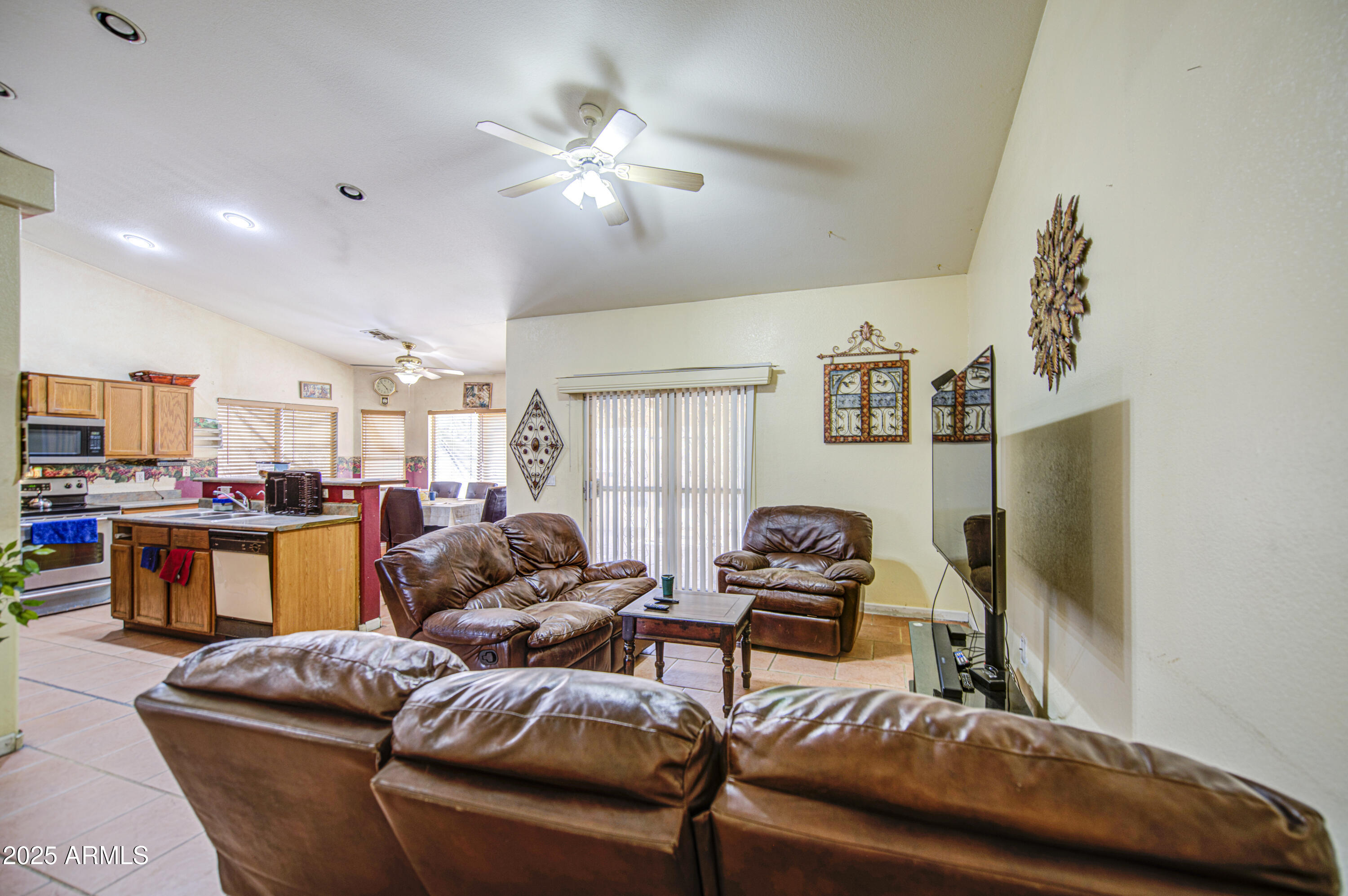 8530 West Berkeley Road Phoenix, AZ 85037 - Photo 11 of 48 a living room with furniture a large window and a flat screen tv