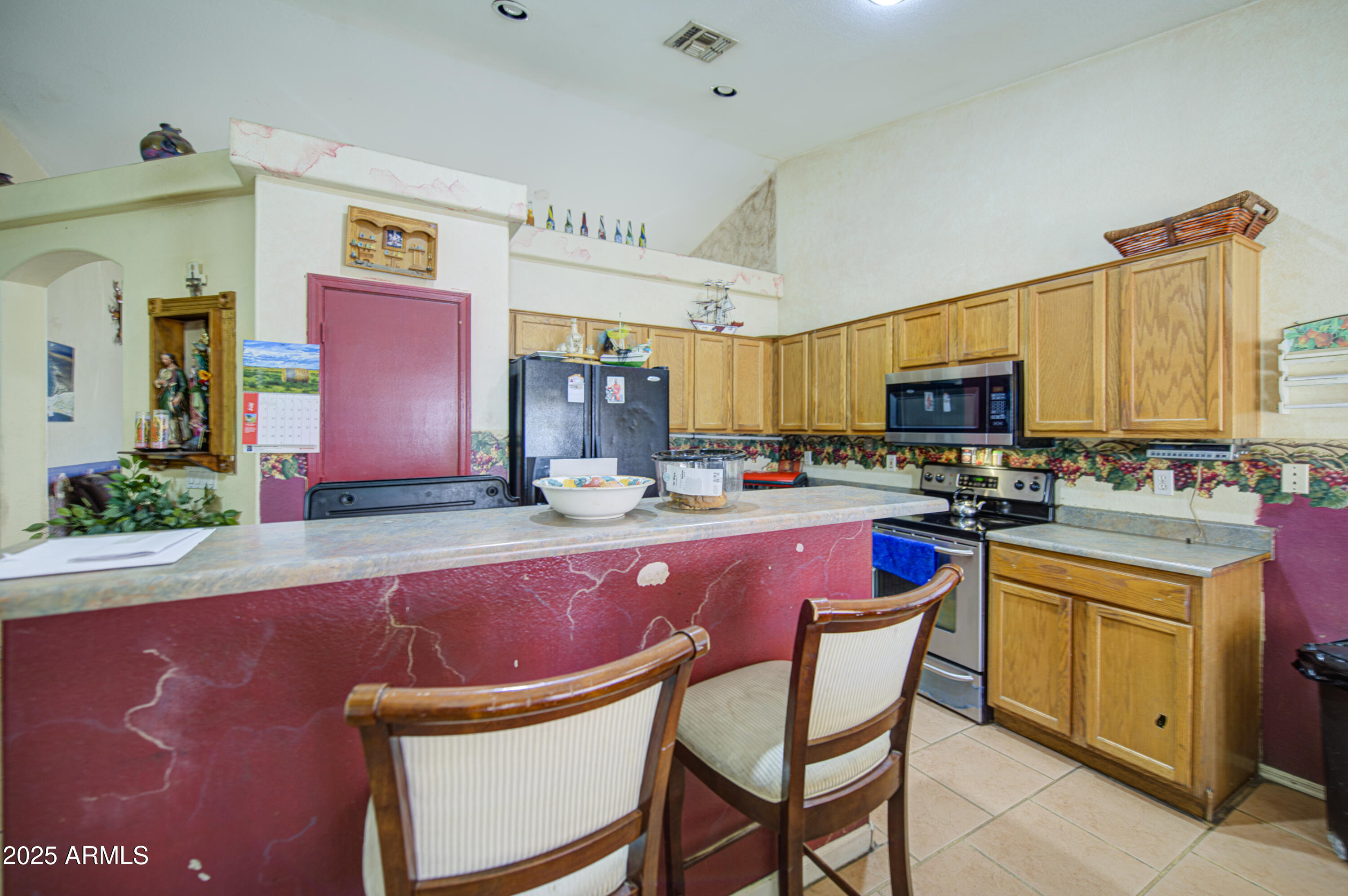 8530 West Berkeley Road Phoenix, AZ 85037 - Photo 17 of 48 a kitchen with stainless steel appliances granite countertop a sink a stove a refrigerator cabinets and chairs