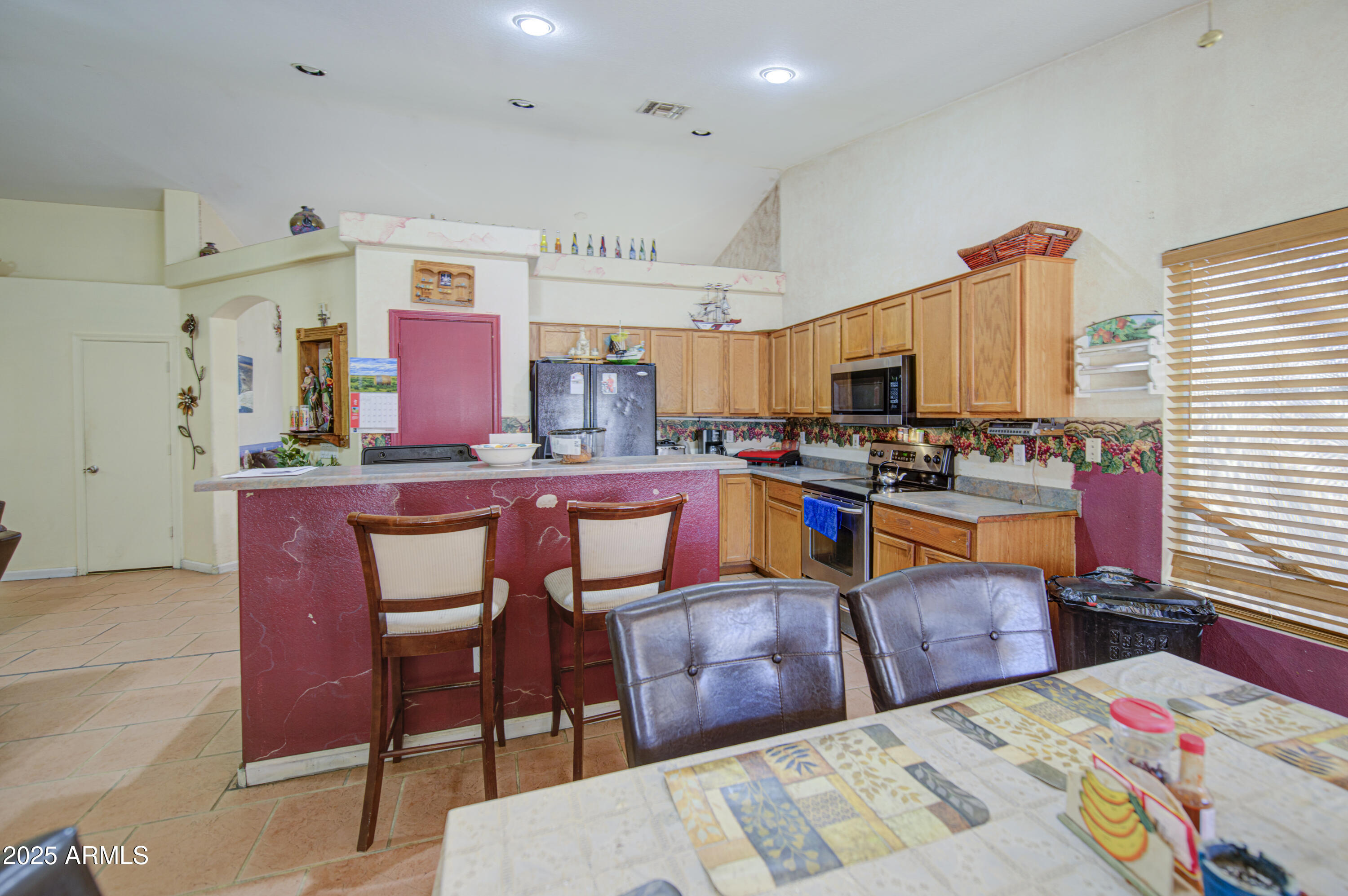 8530 West Berkeley Road Phoenix, AZ 85037 - Photo 18 of 48 a kitchen with stainless steel appliances kitchen island granite countertop a sink a stove a dining table and chairs