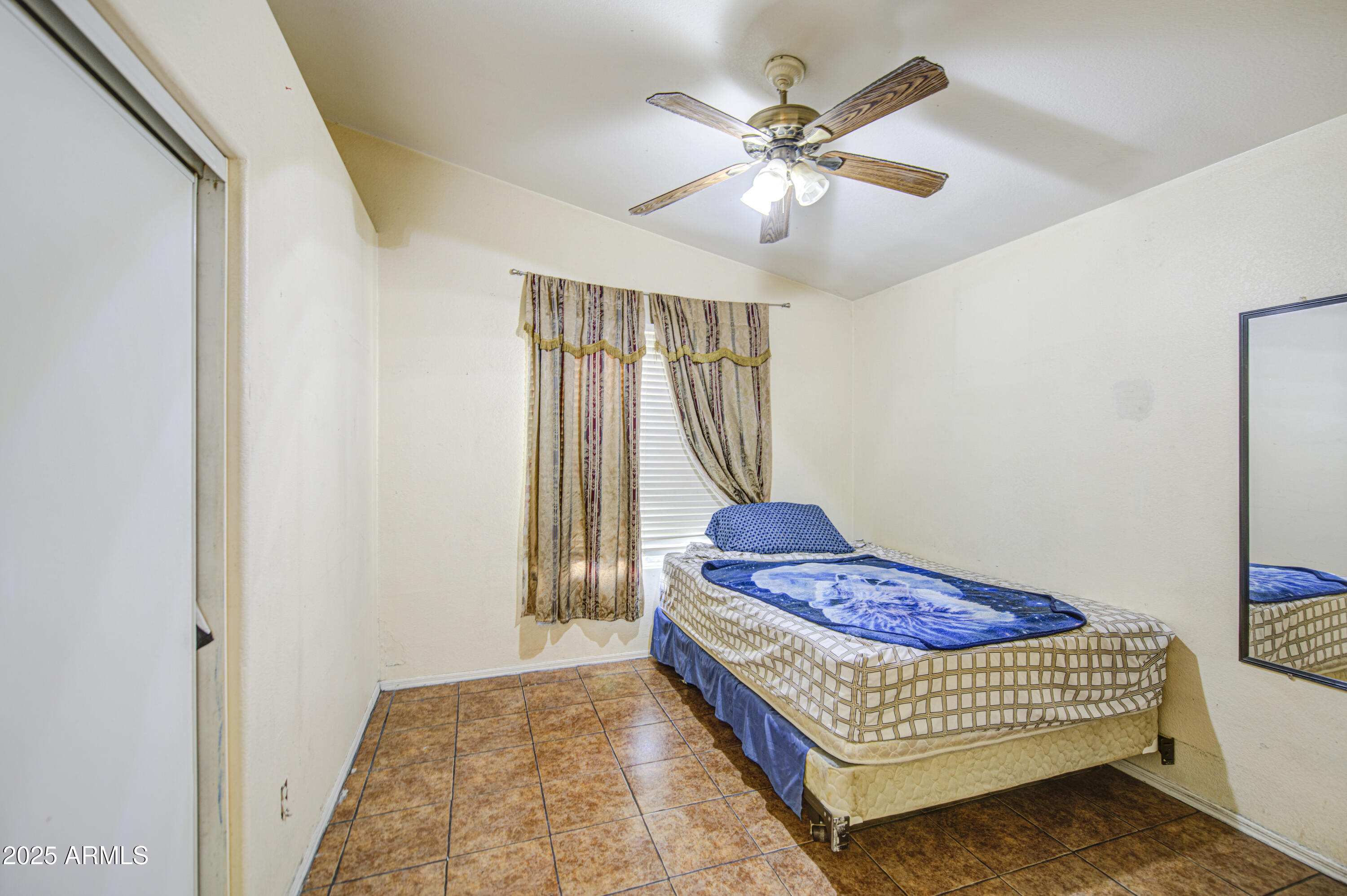 8530 West Berkeley Road Phoenix, AZ 85037 - Photo 33 of 48 a bedroom with a bed and a chandelier