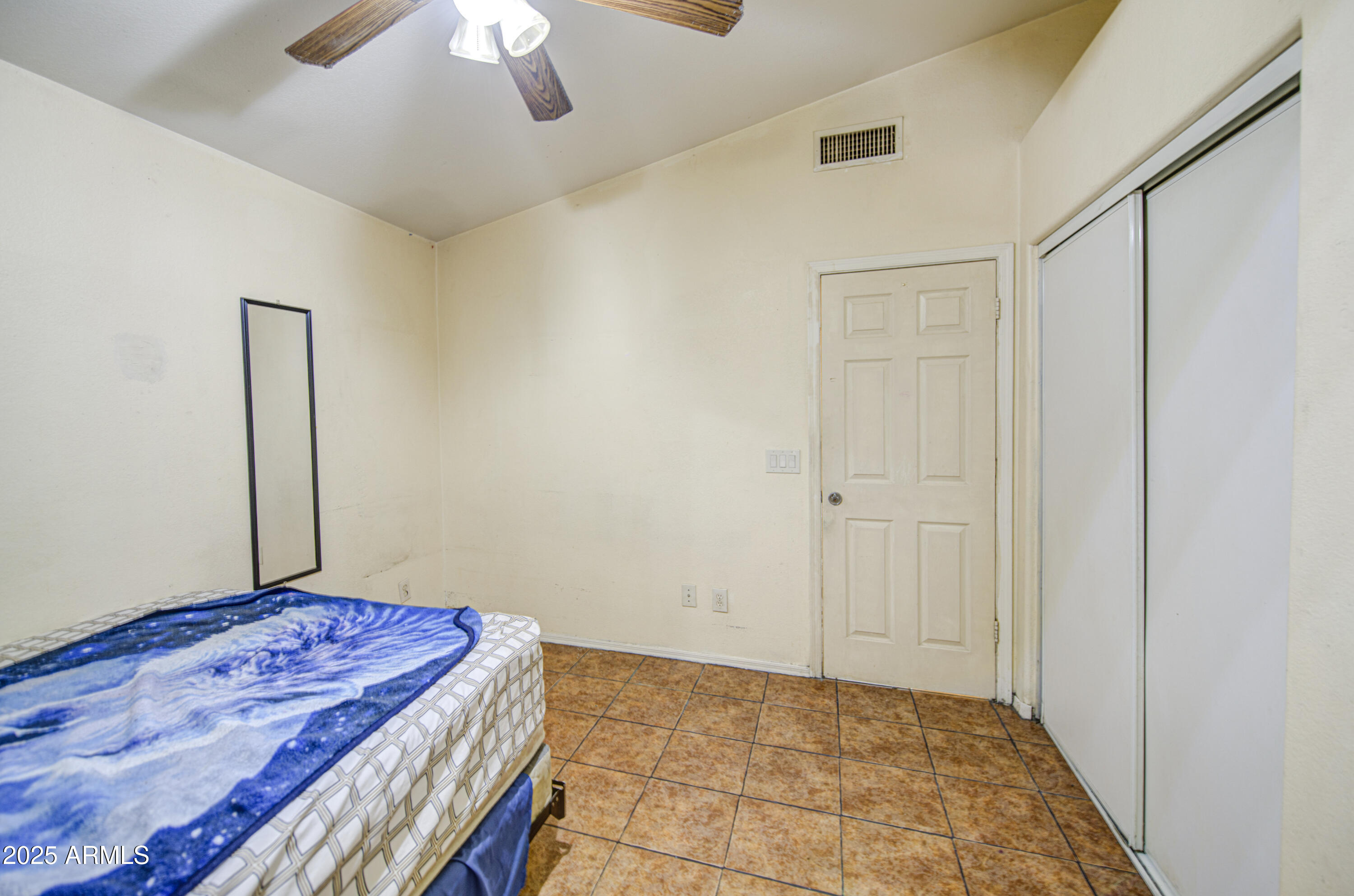 8530 West Berkeley Road Phoenix, AZ 85037 - Photo 34 of 48 a bedroom with a bed and a chandelier fan