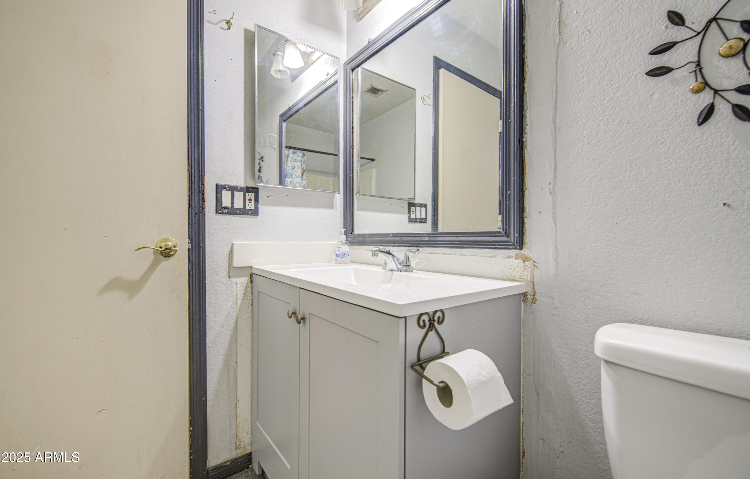 8530 West Berkeley Road Phoenix, AZ 85037 - Photo 39 of 48 a bathroom with a sink a toilet and mirror